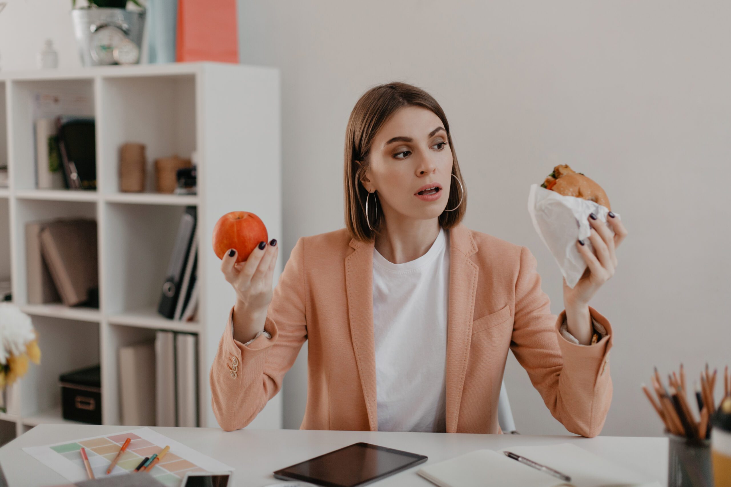 picture business woman pink jacket sitting workplace woman choose tasty burger wholesome apple scaled